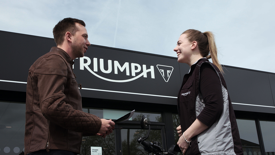 Man and woman outisde Triumph dealership