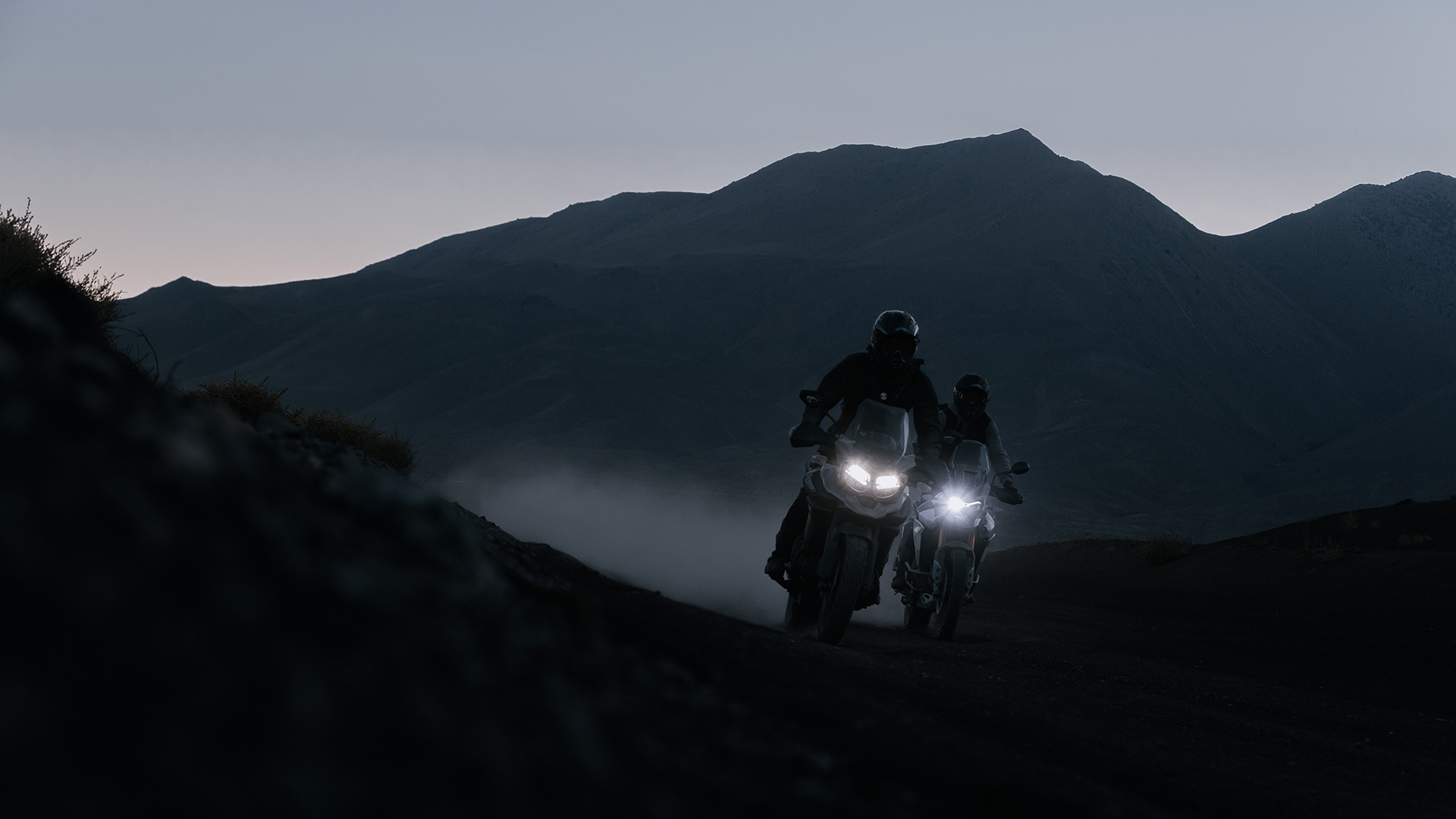 Two Triumph Tigers riding across the desert