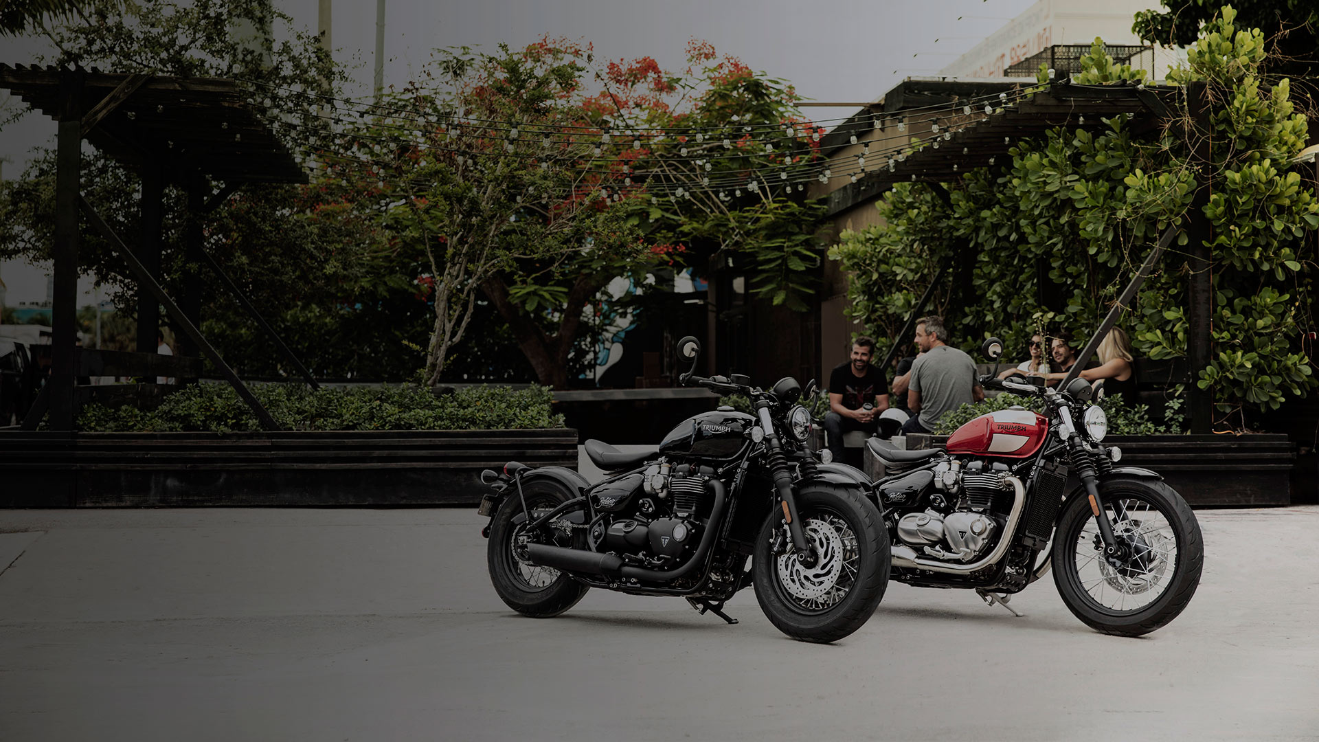 Two Triumph Bonneville Bonnevilles in garden scene