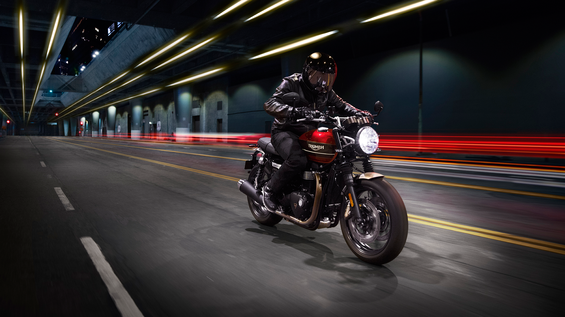 All-new Triumph Speed Twin travelling at speed through city underpass in darkness
