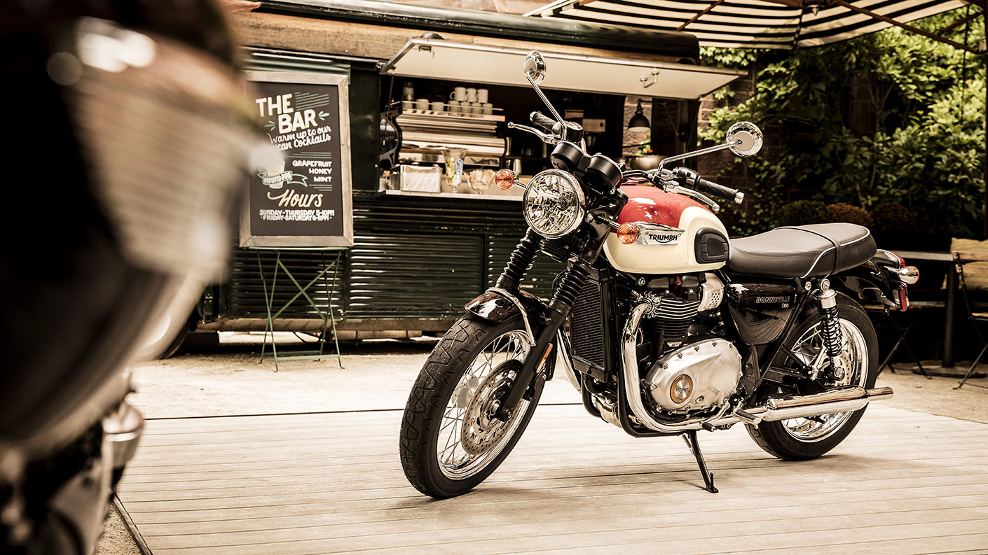 Parked Triumph Bonneville T100 in orange and white colour variant