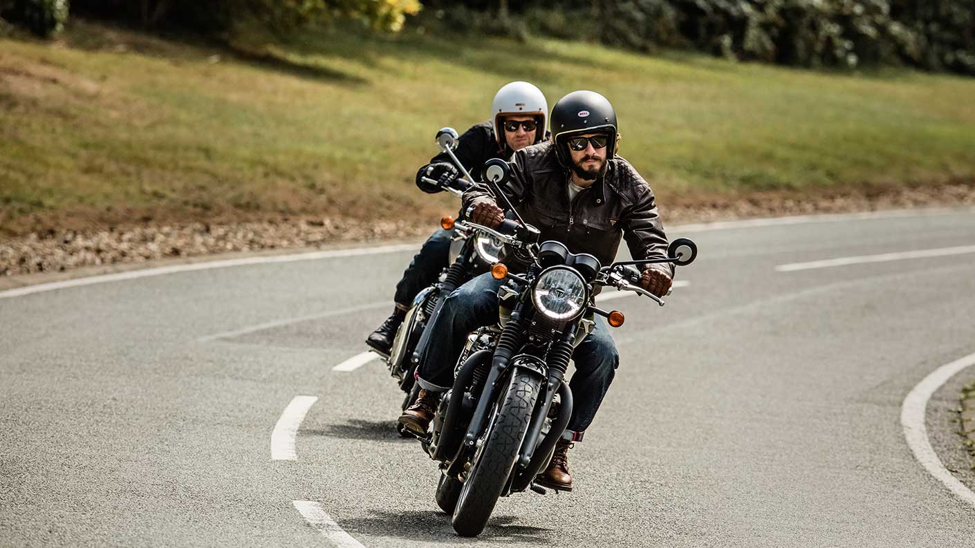 Triumph bonneville T120s riding at speed down road
