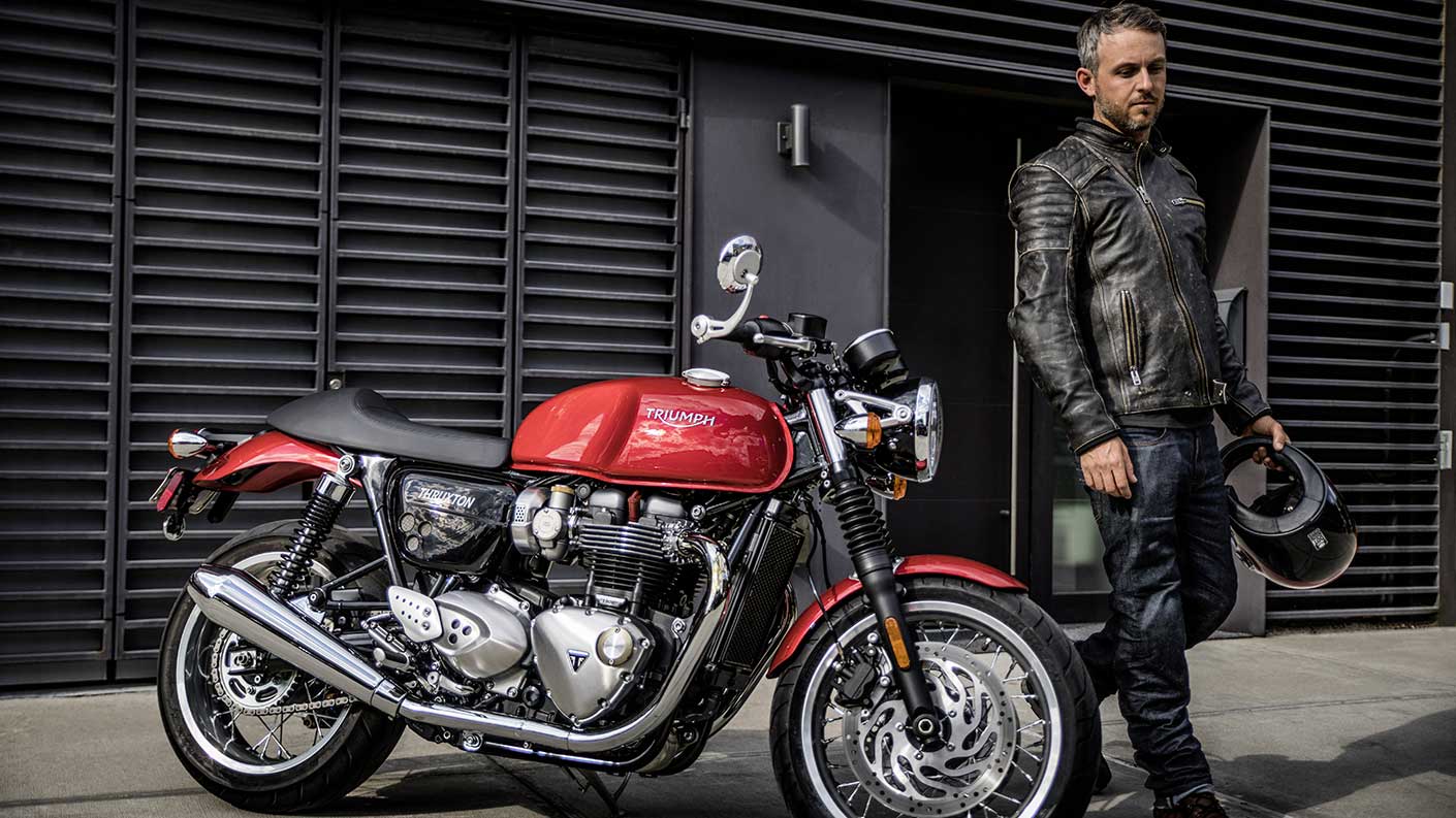 Rider next too his Red Triumph Thruxton 1200